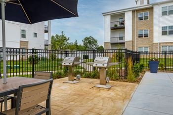 A patio area with a table, chairs, and umbrella.